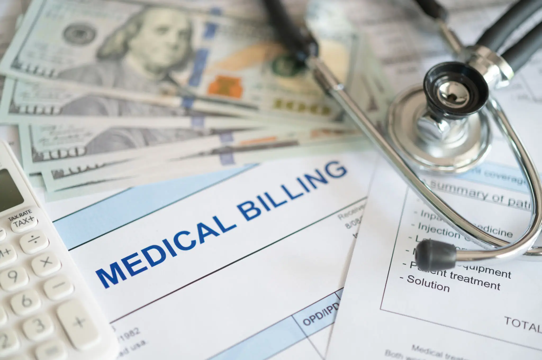 Medical billing paperwork with money and stethoscope.